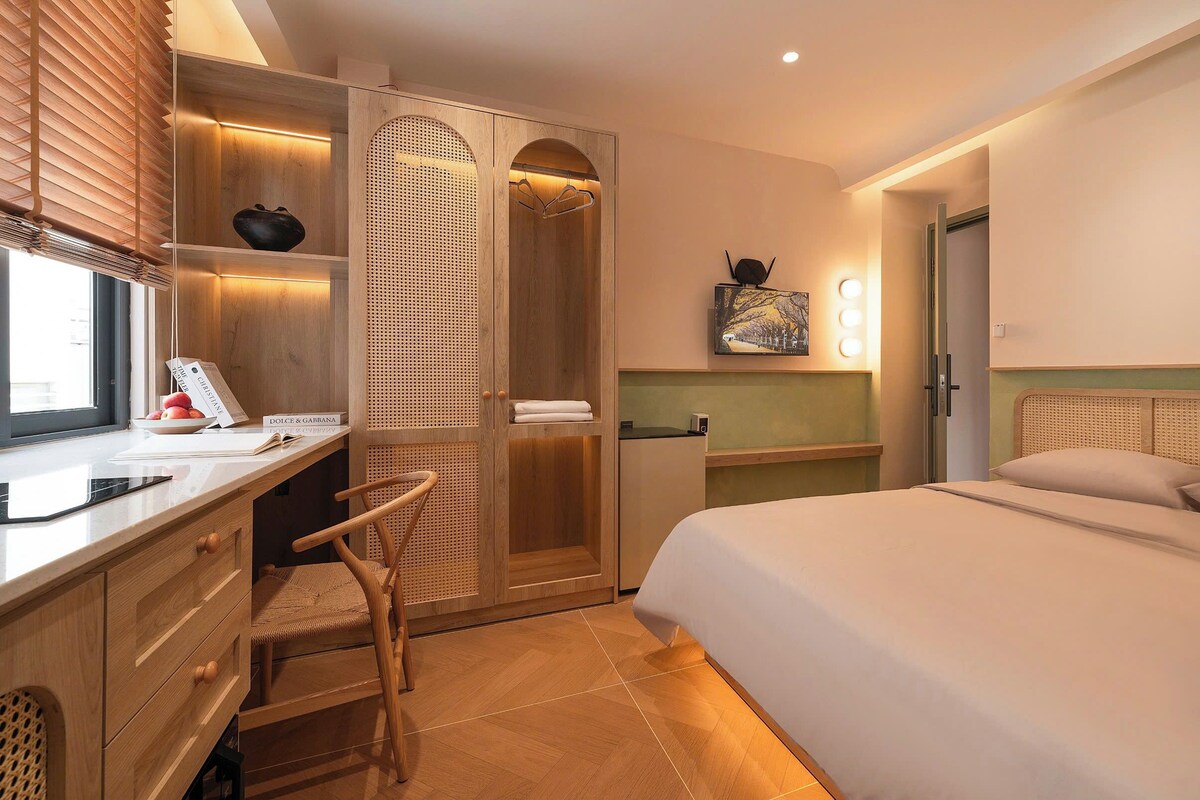 A hotel room with a bed, desk, chair, and a walk-in closet.