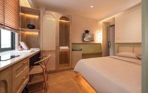 A hotel room with a bed, desk, chair, and a walk-in closet. - Phuc Loc Premier (Ben Thanh)