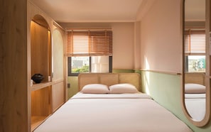A bedroom with a bed, wooden wardrobe, and a window with blinds. - Phuc Loc Premier (Ben Thanh)