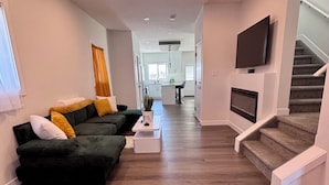 Ein modernes Wohnzimmer mit Sofa, Couchtisch und Wandfernseher.
