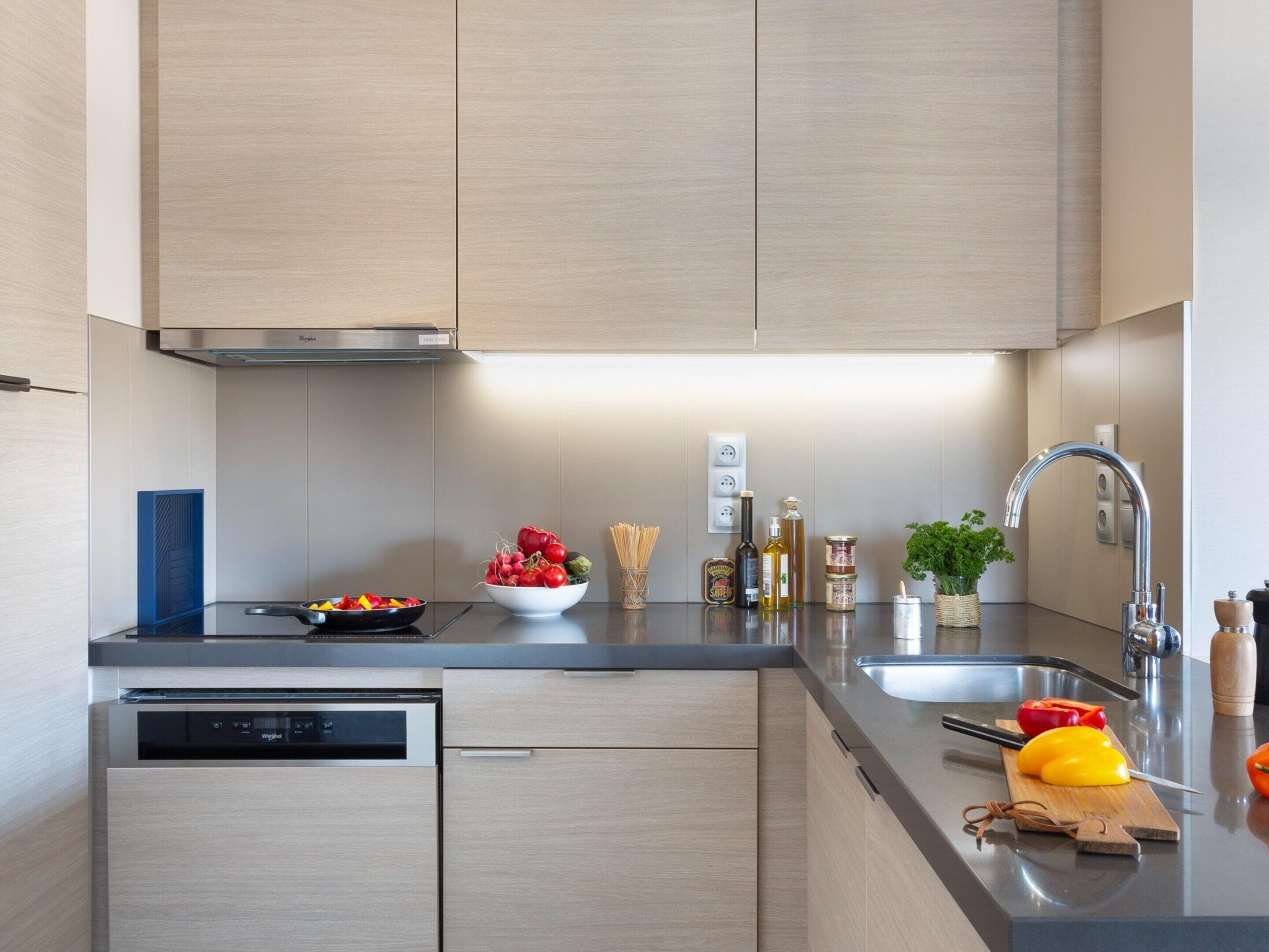 Een moderne keuken met een vaatwasser, een spoelbak en een fornuis.