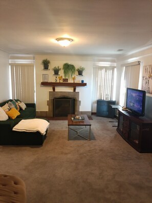 A living room with a fireplace, a television, a sofa, and a coffee table.