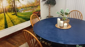 A dining area with a round table, chairs, candles, and a large wall mural. - Charming Upper Flat 10 mins from Downtown Det-10 mins from Nautical Mile (Detroit)