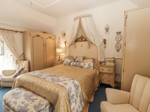 A bedroom with a bed, a nightstand, a chair, a wardrobe, and a bedside table. - WHITE HEATHER COTTAGE, family friendly in Killaloe, County Clare (Killalou)