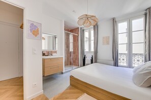 Una camera da letto con un letto, un bagno con doccia e un balcone con vista.
