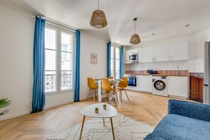 Un soggiorno moderno con angolo ristoro, cucina e zona lavanderia.