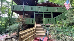 Eine Holzhütte mit einer Holztreppe, einer Flagge und einer Veranda.