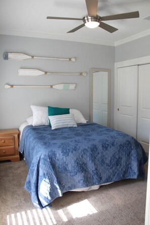 A bedroom with a bed, a ceiling fan, a dresser, and a door. - Beach Beyond Belief + Private pool+ free bikes (Rosemary Beach)