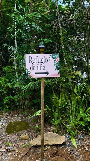 Ein Wegweiser mit der Aufschrift 'Refugio da ilha' und einem nach rechts zeigenden Pfeil.