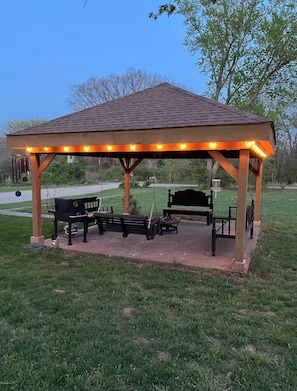 A gazebo with benches and string lights.