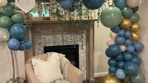 Una habitación con chimenea, un sofá y una pared decorada con globos.