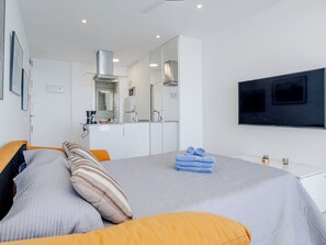 A modern hotel room with a bed, a TV, a kitchenette, and a bathroom. - Horizonte by Interhome (Calpe/Calp)