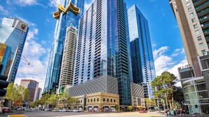 A modern urban street with high-rise buildings, a historic building with a yellow facade, and a clear blue sky. - Exclusive Stays - SB Grand (Southbank)