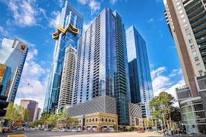 A modern urban street with high-rise buildings, a traffic light, and a pedestrian crossing. - Exclusive Stays - SB Grand (Southbank)