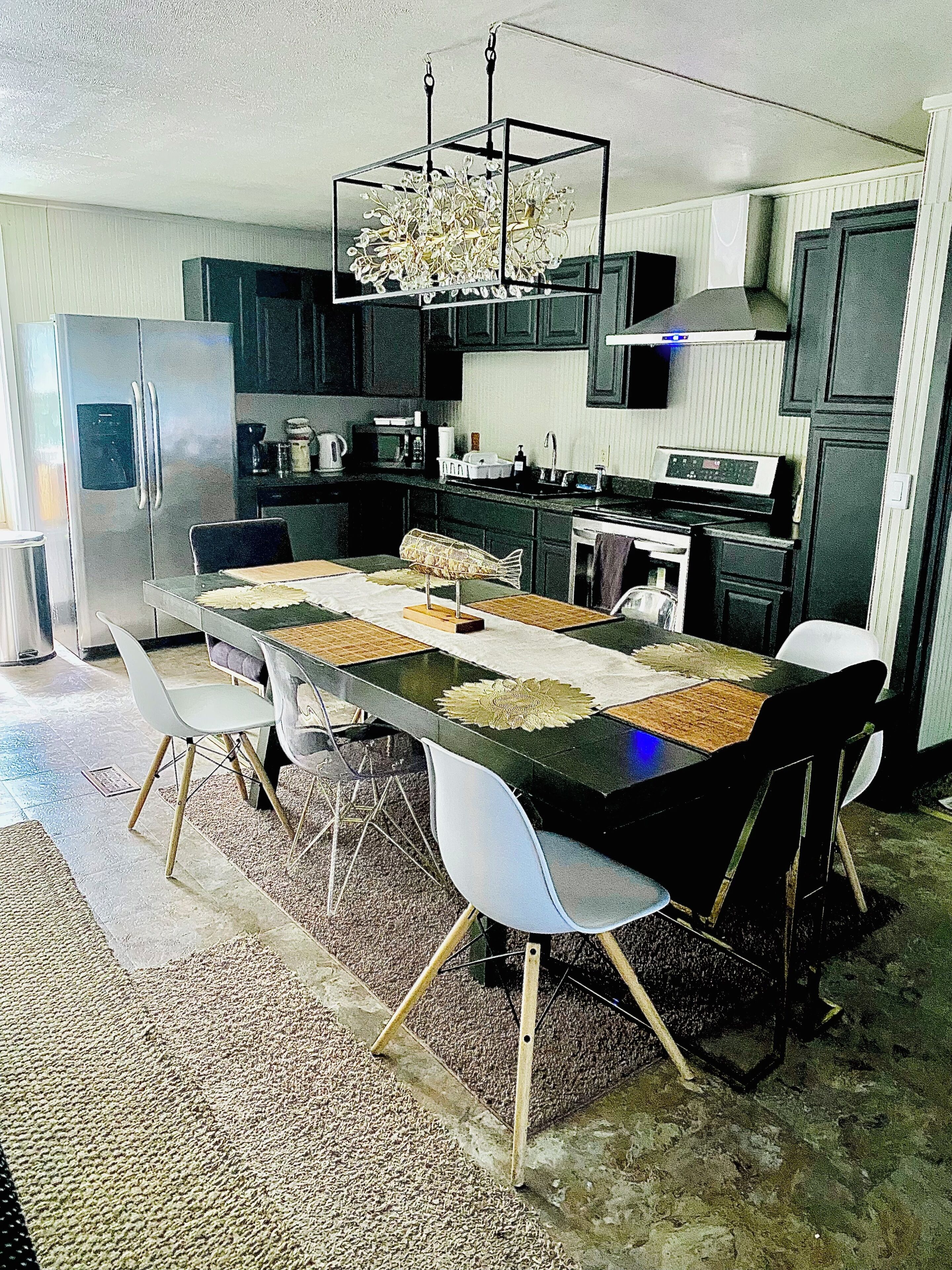Une cuisine moderne avec une table à manger, des chaises et un lustre.