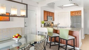 A modern kitchen with a central island, wooden cabinets, and stainless steel appliances. - Christmas in Florida! 2 Bedroom, 2 Bath Villa – Marriott’s Grande Vista, Orlando (Orlando)