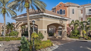 A hotel entrance with a covered walkway, palm trees, and a well-maintained garden. - Christmas in Florida! 2 Bedroom, 2 Bath Villa – Marriott’s Grande Vista, Orlando (Orlando)