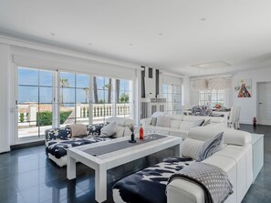 A spacious living area with a large window, a white sofa set, a coffee table, and a dining area. - Medussa by Interhome (Dénia)