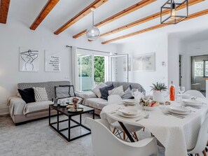 Ein modernes Wohnzimmer mit einer Couch, einem Esstisch und Kunstwerken.