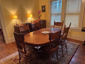A dining room with a wooden table, chairs, a rug, and two wall-mounted lamps. - Cozy 1-bedroom bungalow in East Atlanta (Atlanta)