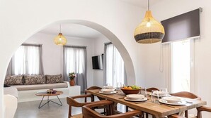 Un comedor con una mesa de madera, sillas e iluminación colgante.