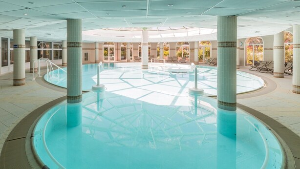 A large indoor swimming pool with clear water, surrounded by columns, and a bench near the entrance. - Stunning 4-person Sea View Haven (Roquebrune-sur-Argens)