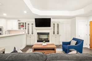 A living room with a fireplace, sofa, coffee table, and TV. - Keep Me In Mind | Pool | Hot Tub | New Braunfels (New Braunfels)