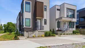 Un immeuble résidentiel moderne à plusieurs étages, doté d’un toit plat, de grandes fenêtres et de fondations en pierre.