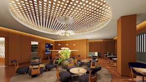 A modern lobby with a circular seating area, wooden paneling, and a unique ceiling design. - Honjin Hiranoya Omeiso (Takayama)