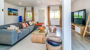 Ein modernes Wohnzimmer mit einer Couch, Couchtisch, Fernseher und einem Gemälde an der Wand.