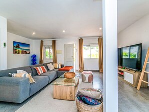 A modern living room with a sofa, coffee table, TV, and a painting on the wall. - Bohemia by Interhome (Calpe/Calp)
