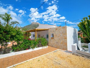 A house with a stone wall, a tiled patio, and a mountain in the background. - Bohemia by Interhome (Calpe/Calp)