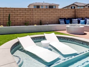A swimming pool with lounge chairs and a fire pit. - Desert Oasis • Heated Pool & Spa • Sleeps 10 (Indio)