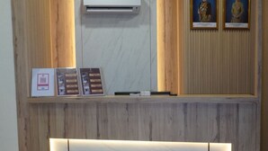 A reception desk with a marble top, wooden paneling, and framed certificates. - Hotel Shlyo - Taman Nusantara Prima (Gelang Patah)