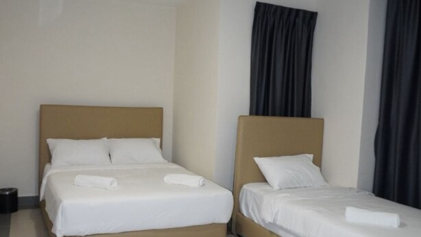 A hotel room with two beds, a ceiling light, and a curtain on the window. - Hotel Shlyo - Taman Nusantara Prima (Gelang Patah)