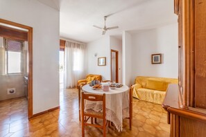 A dining area with a round table, chairs, and a ceiling fan. - Leuca Relax&Sea n.7C, Castrignano del Capo, Italy (Castrignano del Capo)