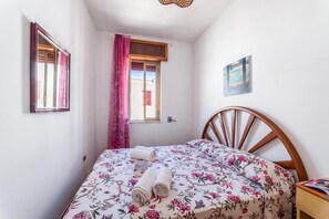 A bedroom with a bed, a window with curtains, a wall-mounted picture, and a bedside table with a book. - Leuca Relax&Sea n.7C, Castrignano del Capo, Italy (Castrignano del Capo)