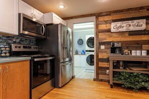 A kitchen with stainless steel appliances, a coffee bar, and a sign reading 'Mountain Life Coffee & Tea.' - Adorable High Mountain Retreat with HOTTUB! (Duck Creek Village)