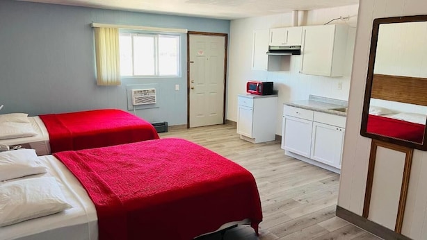 A room with two beds, a kitchenette, a mirror, and a door. - SANDS MOTEL (Boscobel)