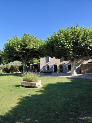 A building with a patio area, a tree, and a grassy lawn. - The essentials in Provence (Noves)