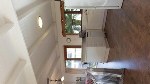 A room with a staircase, a bed with a woven cover, a window with a view of greenery, and a clock on the wall. - All seasons for families
House on the hill 
NOW WITH  nbn, wi-fi and FOXTEL (Rosebud)