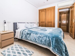 A bedroom with a bed, bedside table, lamp, and wardrobe. - Jardines del Rio by Interhome (Jávea)