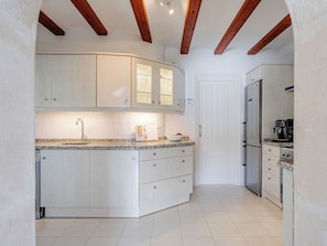 A kitchen with white cabinetry, a granite countertop, and a built-in oven. - El Refugio de Rembrandt by Interhome (Jávea)