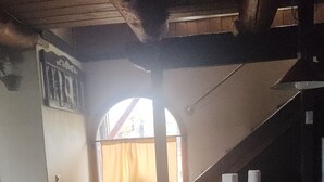 Uma escadaria leva a uma janela com vista, teto de madeira e um balcão com um prato verde.