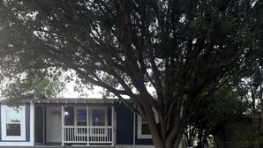 A residential house with a front porch, a large tree, and a concrete sidewalk. - Cowboys Field Stay Near River Walk & Alamo (San Antonio)