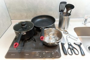 A kitchen with a stove, pots, a colander, and kitchen utensils. - Bellie Sangenjaya by Tranova 2 (Setagaya City)