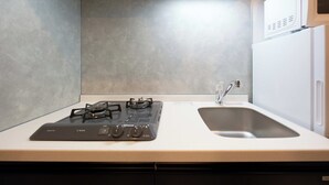 A kitchen with a gas stove, a sink, and a microwave. - Bellie Sangenjaya by Tranova 2 (Setagaya City)