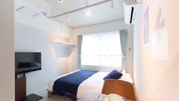 A hotel room with a bed, a TV, a table with a mug and a bowl, and a window with curtains. - Bellie Sangenjaya by Tranova 2 (Setagaya City)