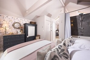 Un dormitorio con cama, cómoda, espejo y zona de ducha.