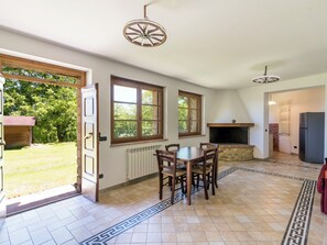 Eine Küche mit Esstisch, Stühlen, Kamin und Kühlschrank.